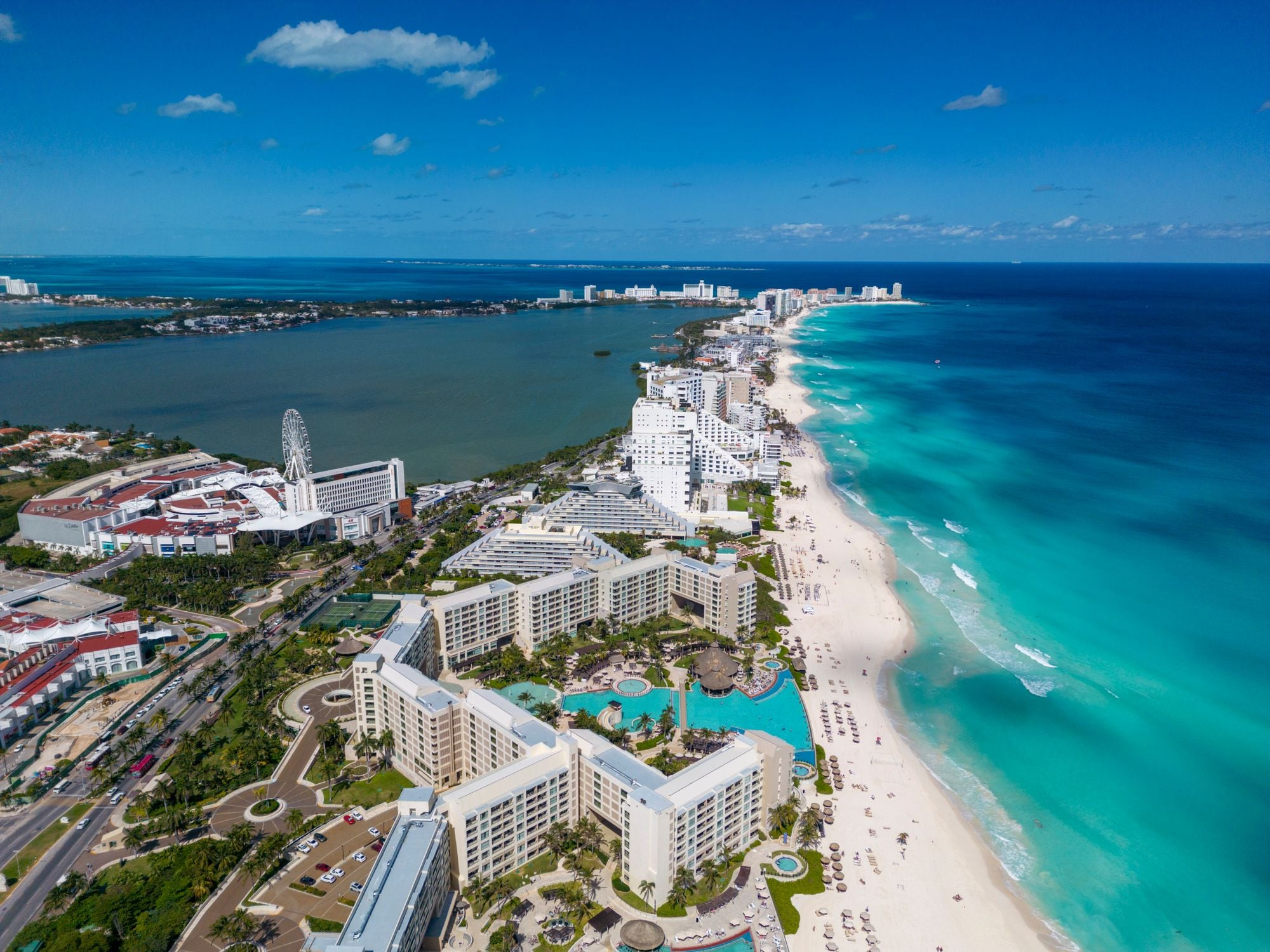 Aerial view of beachfront resorts and turquoise water in Cancún, Mexico.
